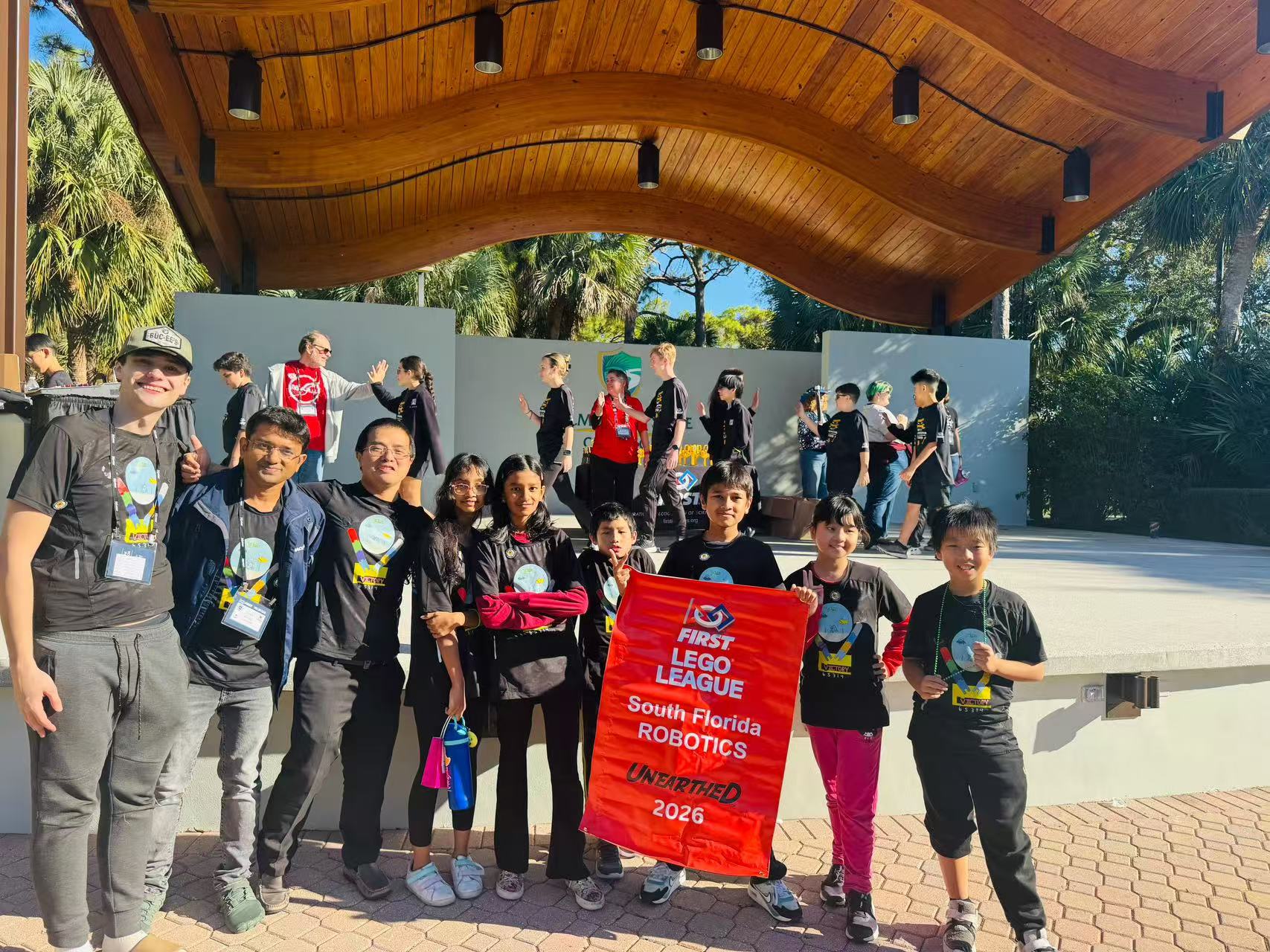 Students gathered near an outdoor stage with event signs