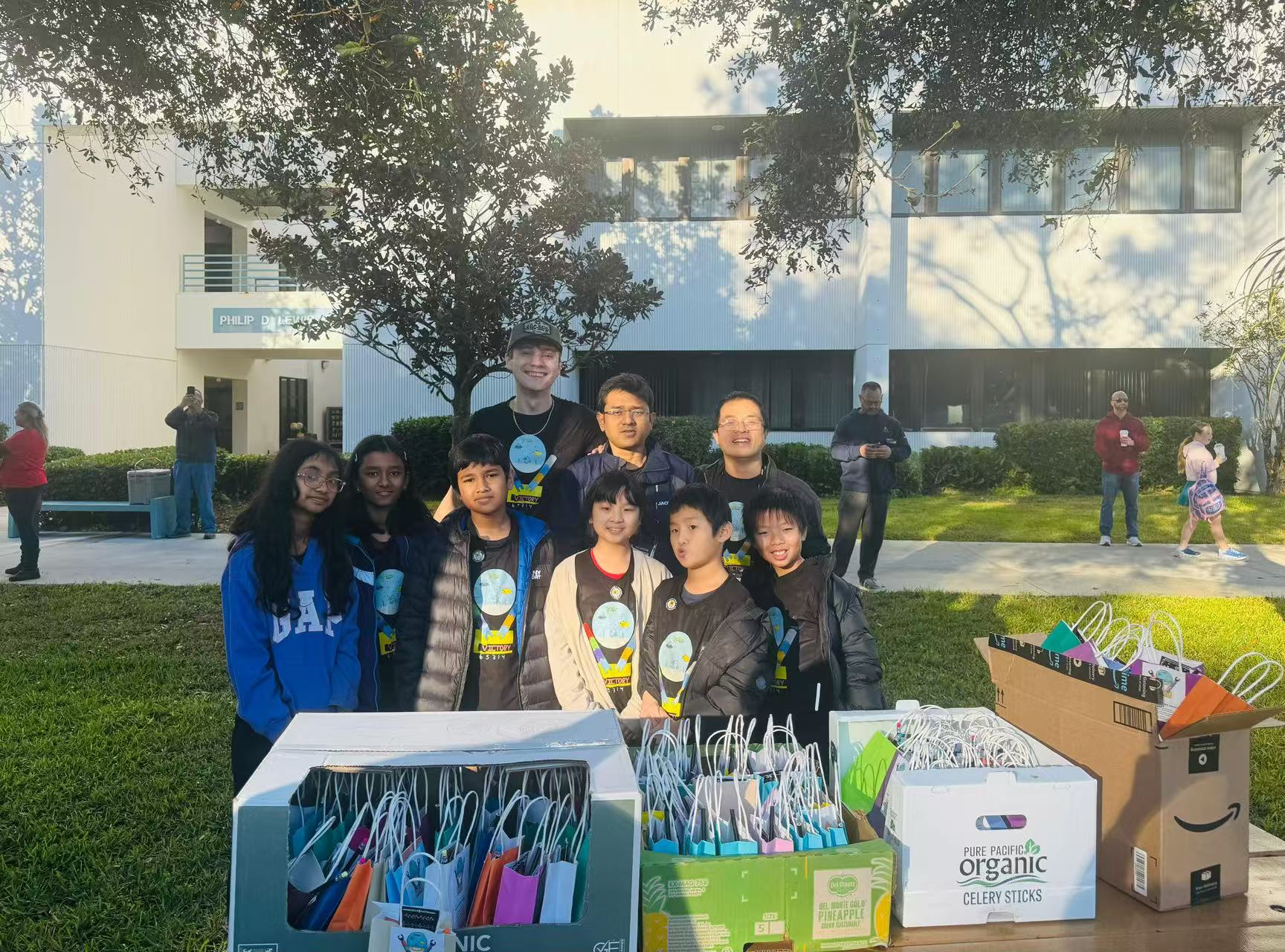 Students hosting an outdoor STEM outreach table with robotics materials