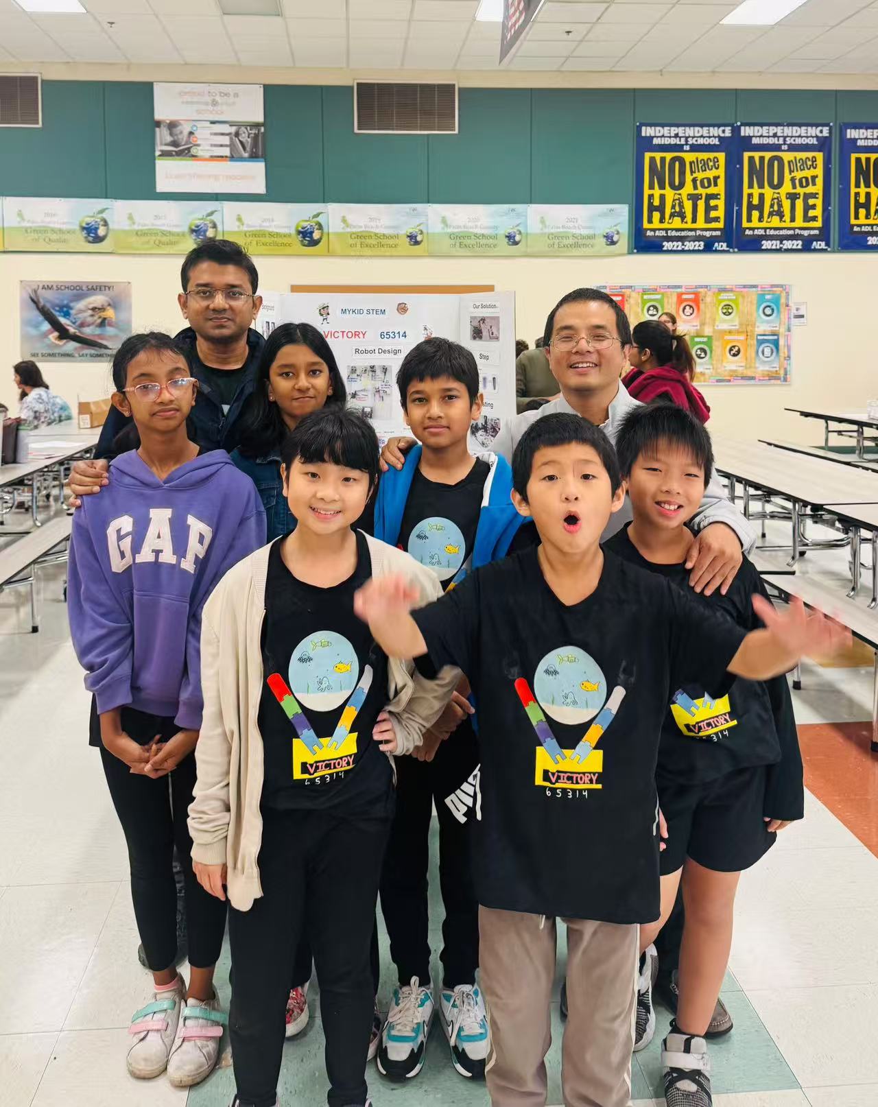 Students and a mentor posing together in a classroom after a STEM activity