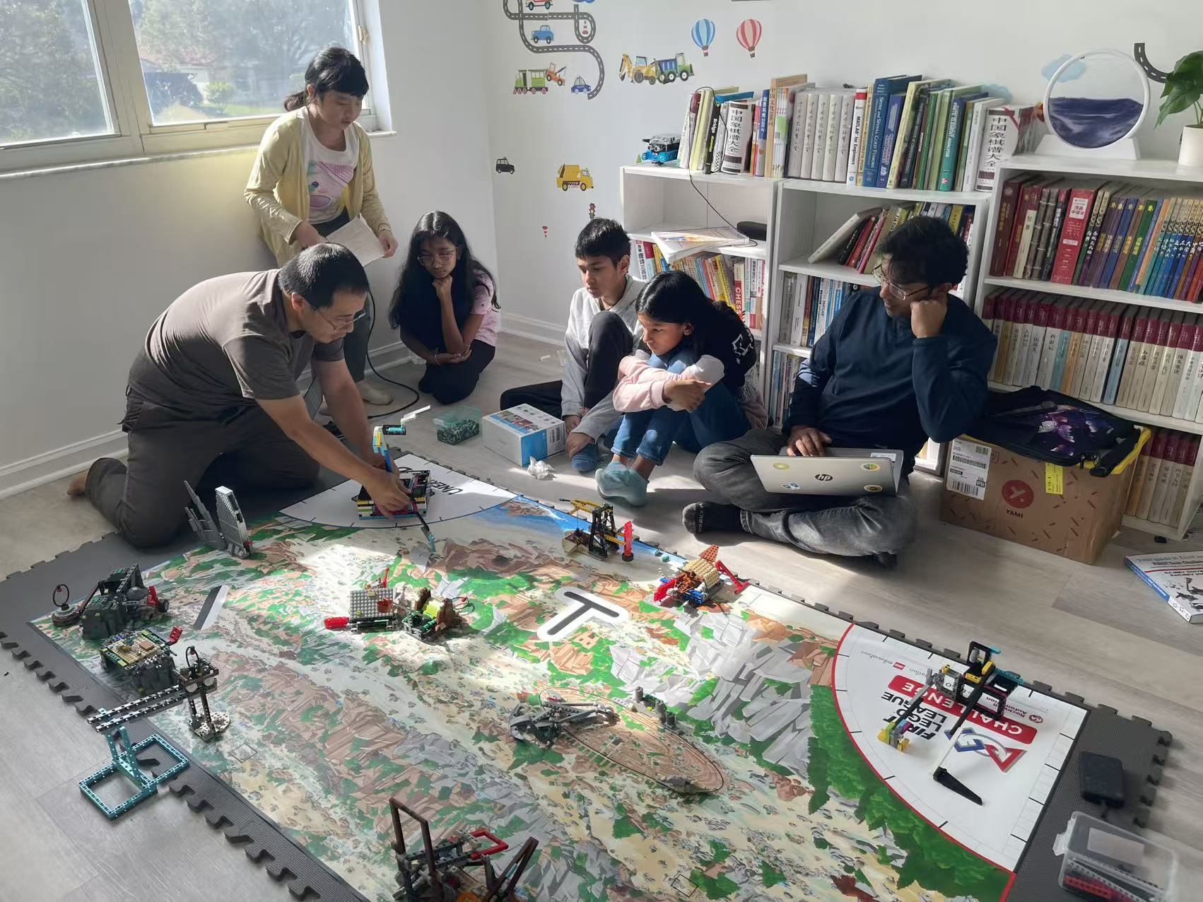 Students learning robotics around a competition field